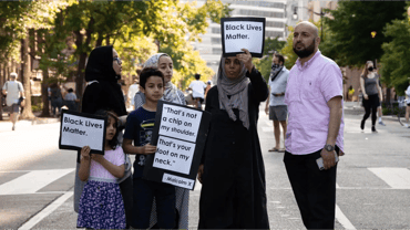 Muslim family holding signs