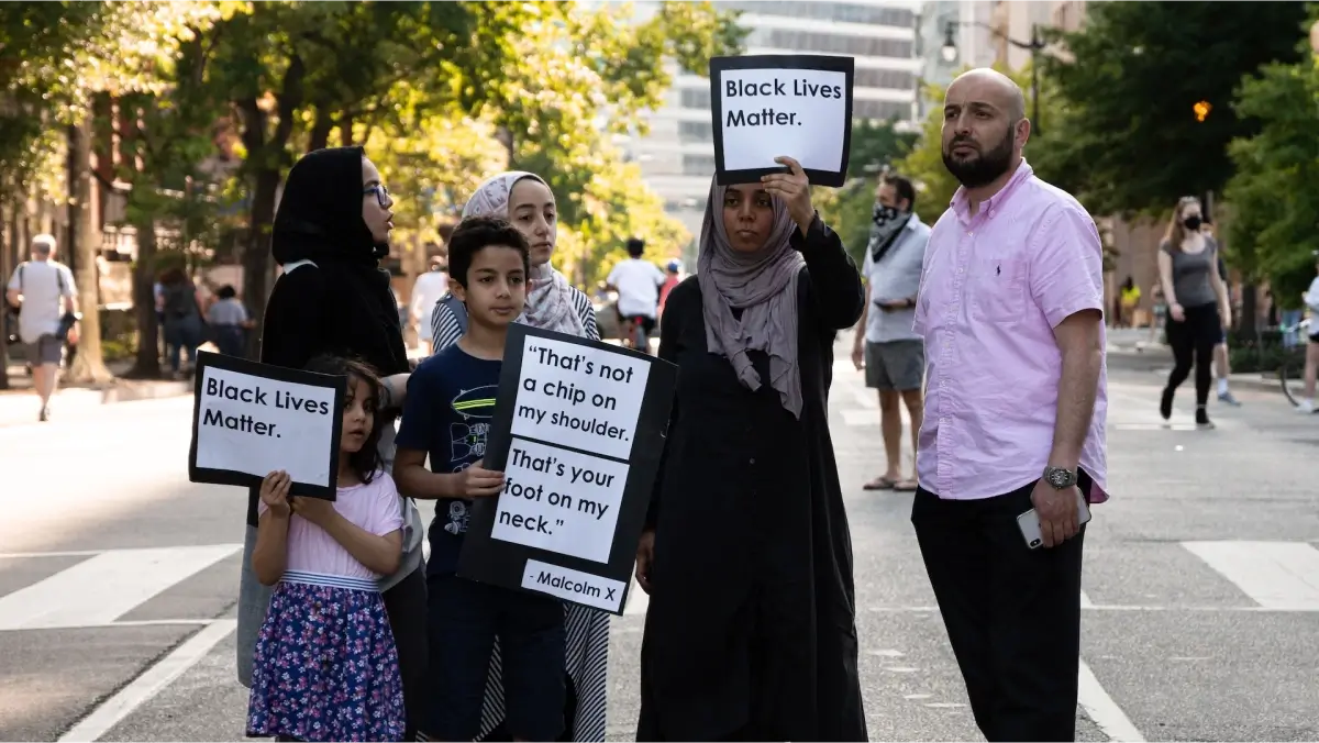 Muslim family holding signs